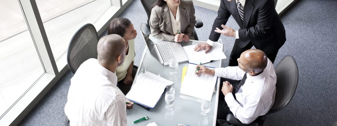 Male and female business people in a meeting at a conference table, overhead view